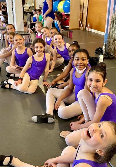 Metrowest Dance Academy class for ages 8 to 11, group of 12 happy students ready for a class to start.